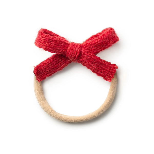 Baby headband featuring a soft red knitted bow attached to a neutral elastic band.