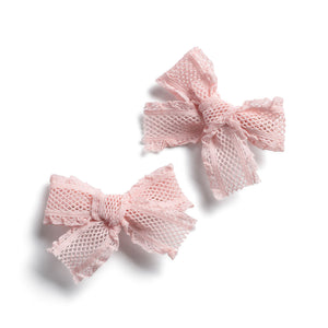 A set of two pink lace hair clips with a bow design, on a white background.