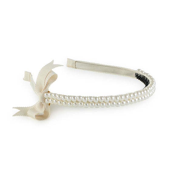 A white headband featuring a double-strand pearl design with a side grosgrain bow.