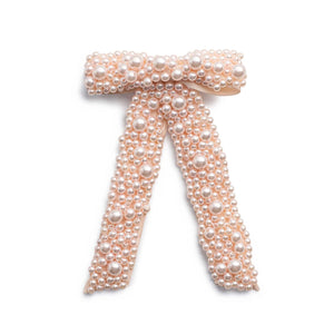 A pale pink pearl bow clip adorned with an all over pearl design.