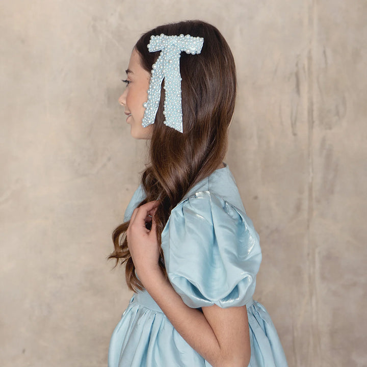 a girl wearing haloluxe's pearl clip in bow shape