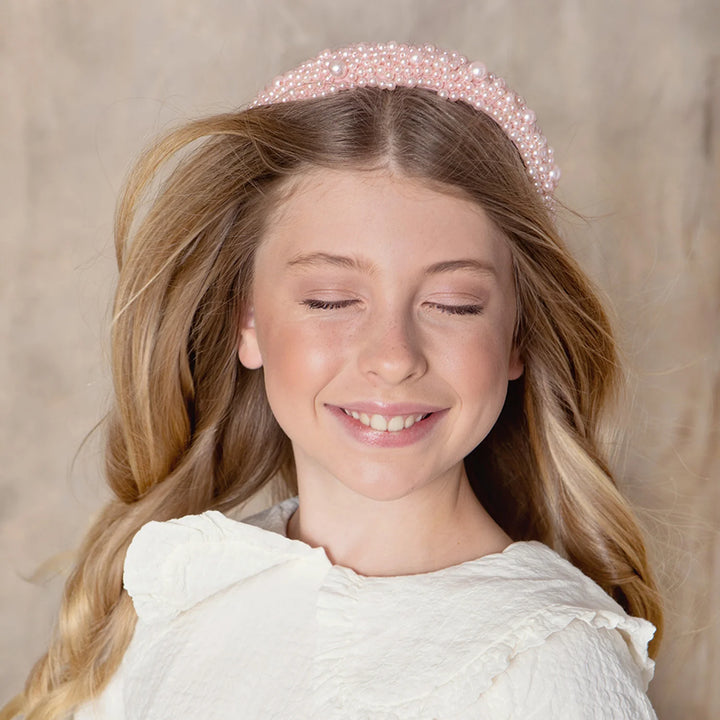 a girl smiling with haloluxe pearl headband in her hair