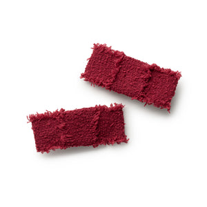Two red textured girl's hair clips on a white background
