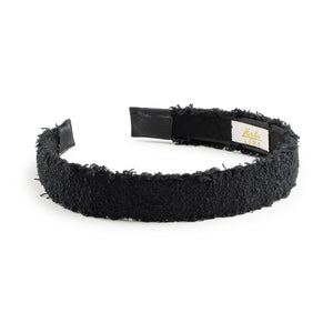 Black textured headband with a brand label on a white background