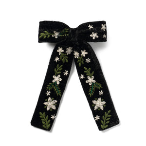 Black embroidered bow hair clip with floral patterns on it