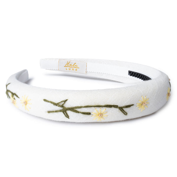 White headband with floral embroidery on a white background