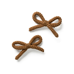 Two brown knitted bow clips on a white background