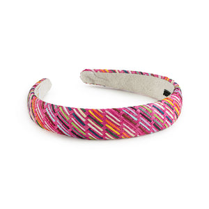 A colorful linen headband with self-textured detailing and rubberized teeth on the inner face, displayed against a white background.