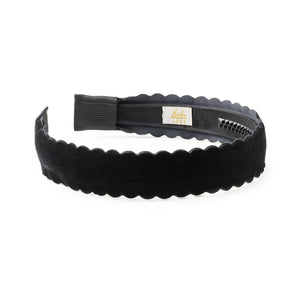 Black scalloped velvet headband with a visible brand label of haloluxe on a white background