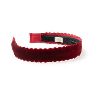Red velvet headband with scalloped edge on a white background
