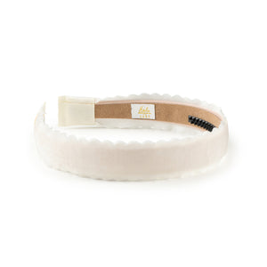White velvet headband with a brown label on a white background