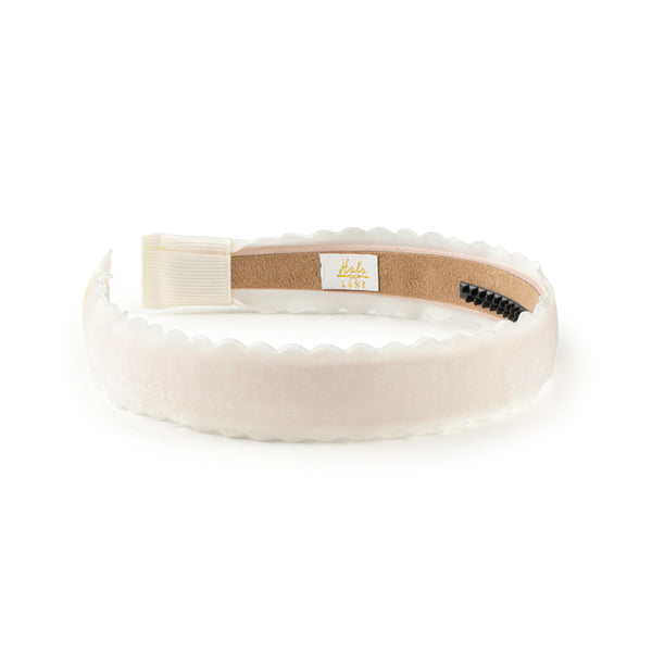 White velvet headband with a brown label on a white background