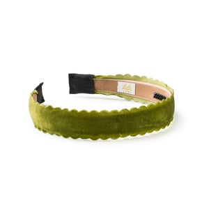 Green velvet headband with scalloped edge on a white background