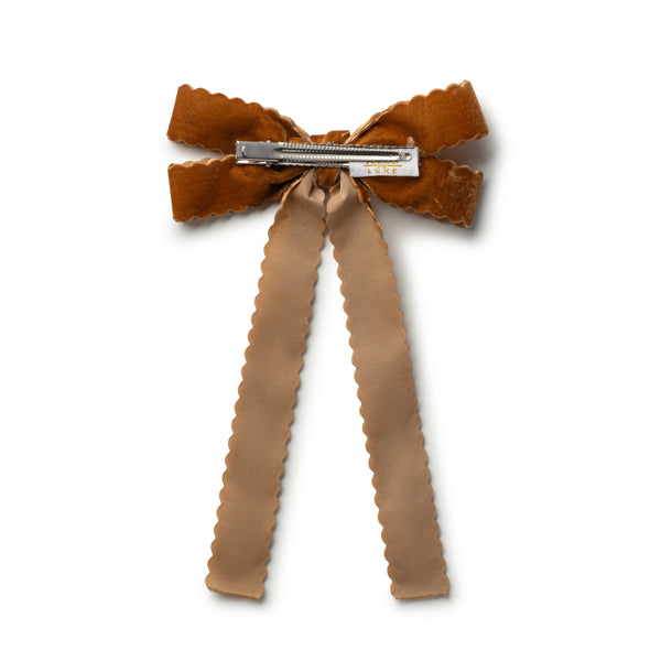 Brown bow hair clip with ruffled edges on a white background