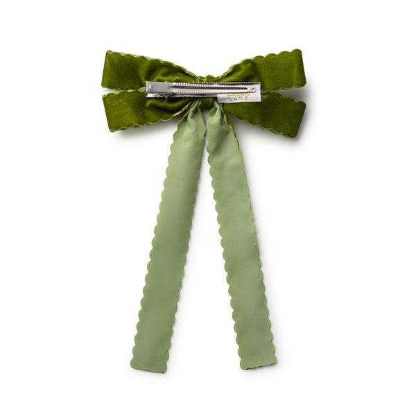 Green bow hair clip with ruffled ribbons on a white background