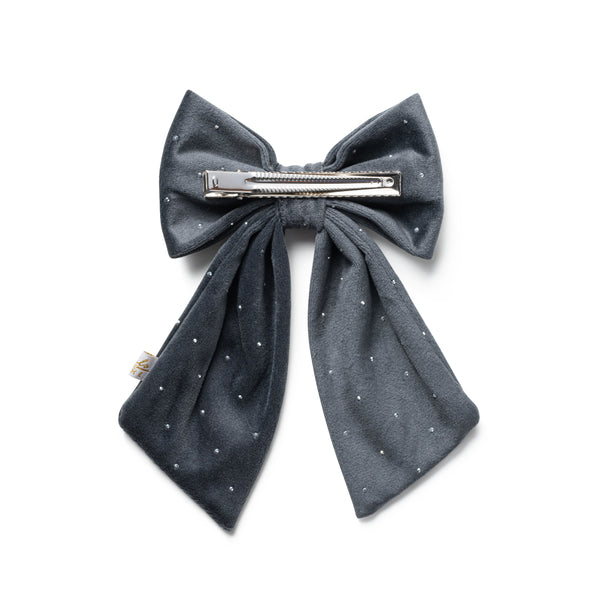 Dark gray polka dot bow hair clip on a white background