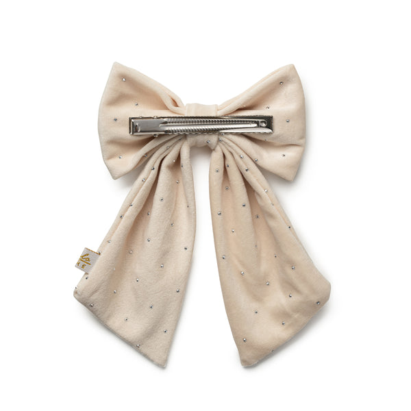 Beige bow hair clip with rhinestone details on a white background