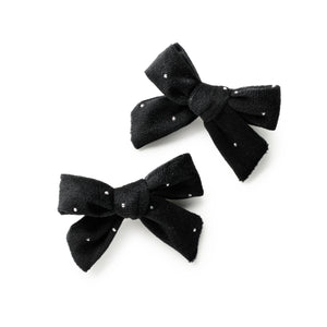 Two black bows with sequins on a white background
