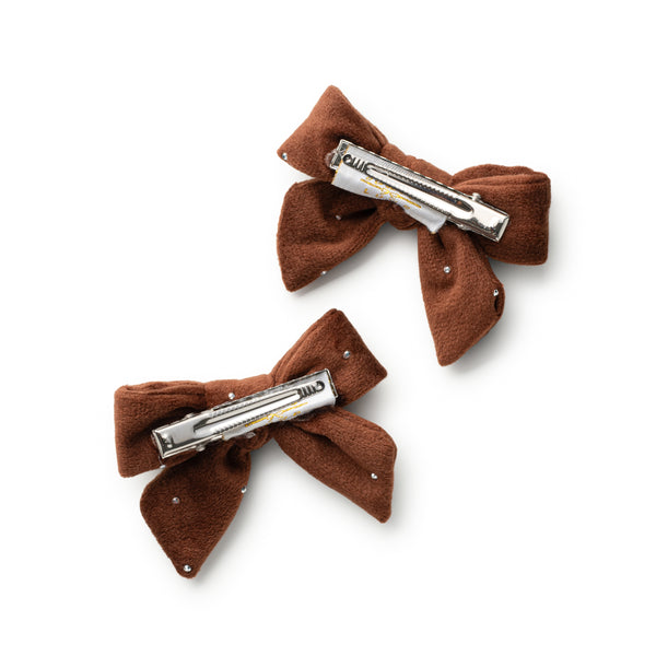Two brown bow hair clips with silver clamps on a white background
