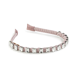 A satin wrapped headband with crystals in a mauve color