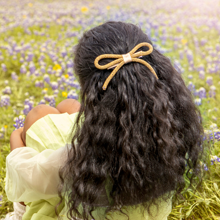 haloluxe pearl bow clip on a girlwith wavy hair