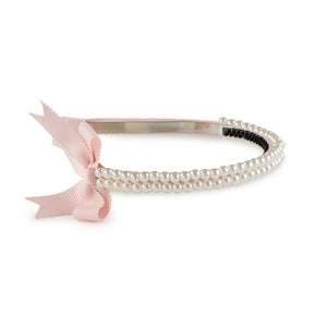A pink headband featuring a double-strand pearl design with a pink grosgrain bow on the side.