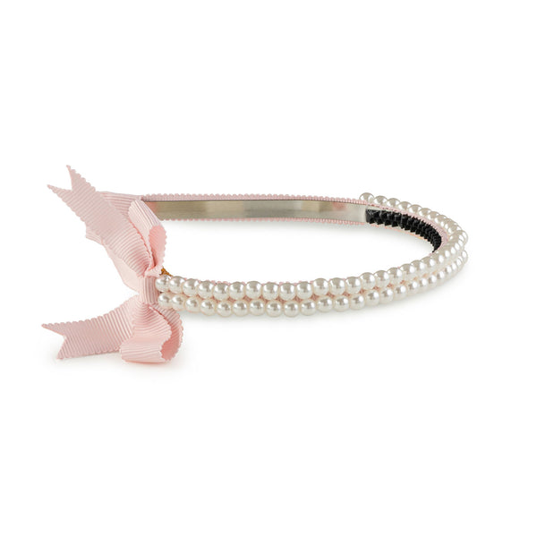A pink headband featuring a double-strand pearl design with a pink grosgrain bow on the side.