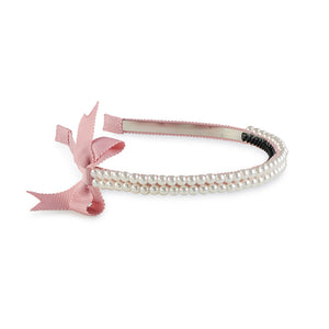 A double-strand pearl headband with a mauve grosgrain bow on the side, displayed on a white background.