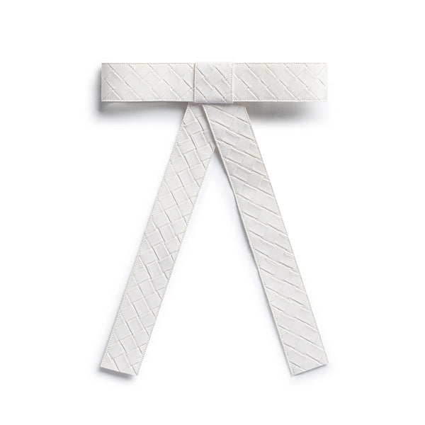 The image is of Halo Luxe Poppy Braided Woven Patent Clip in White it is a luxurious hair accessory designed to blend elegance with functionality.

Its Design & Material is Made from woven patent vegan leather, the clip features a hand-crafted bow knot tail with a self-textured finish.