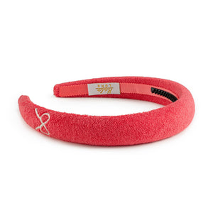 A strawberry colored Halo Luxe Terry cloth Headband for girls with the brand's embroidery on the front.