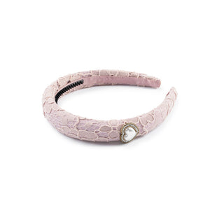 A mauve-colored padded lace headband with heart embellishments and a rhinestone detail in the center.
